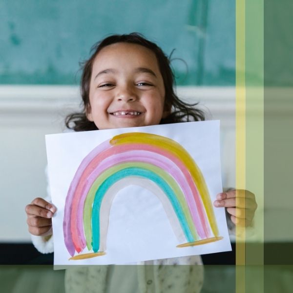 young girl showing her painting of a rainbow