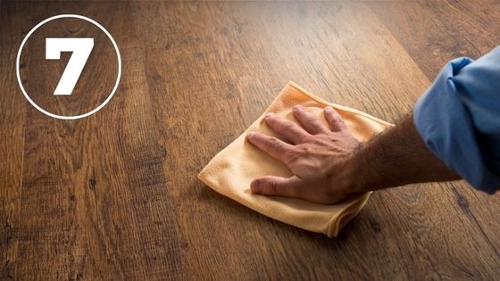 man's hand wiping hardwood floor