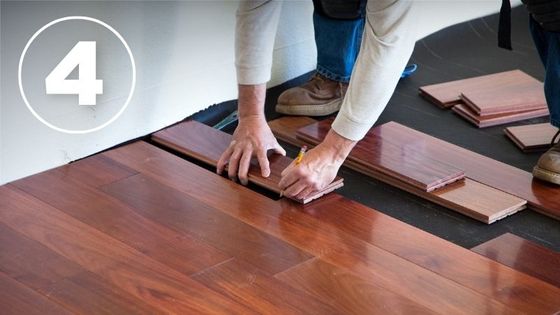 man laying hardwood flooring