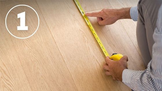 man measuring floor with tape measure