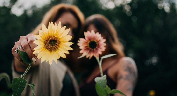 woman holding flowers up blurring their faces