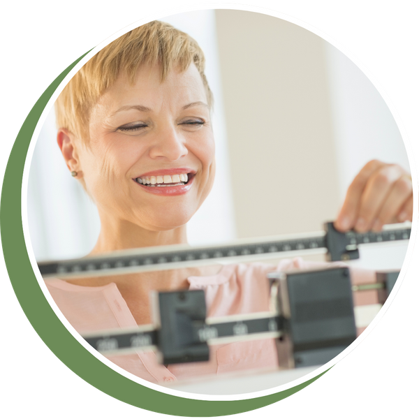 a woman smiling at a weight scale, pleased with her weight loss results