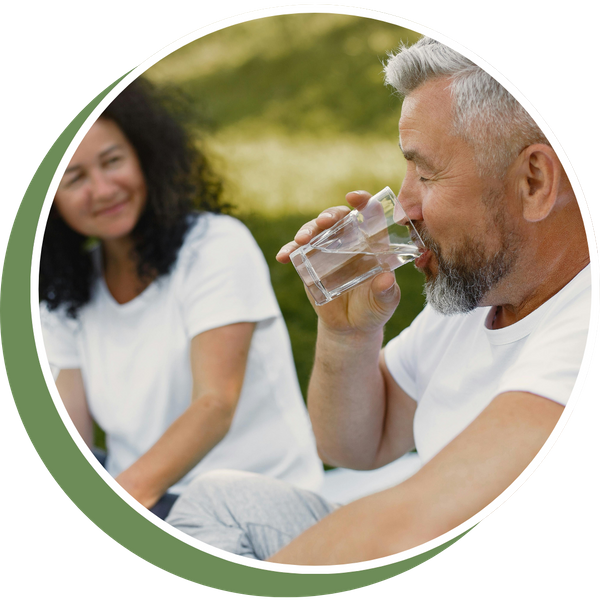older man with woman drinking a glass of water