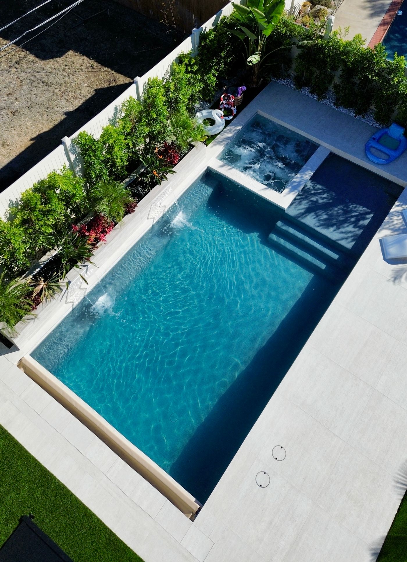 pool with Baja step, spa, raised wall, and tropical landscaping in Woodland Hills.