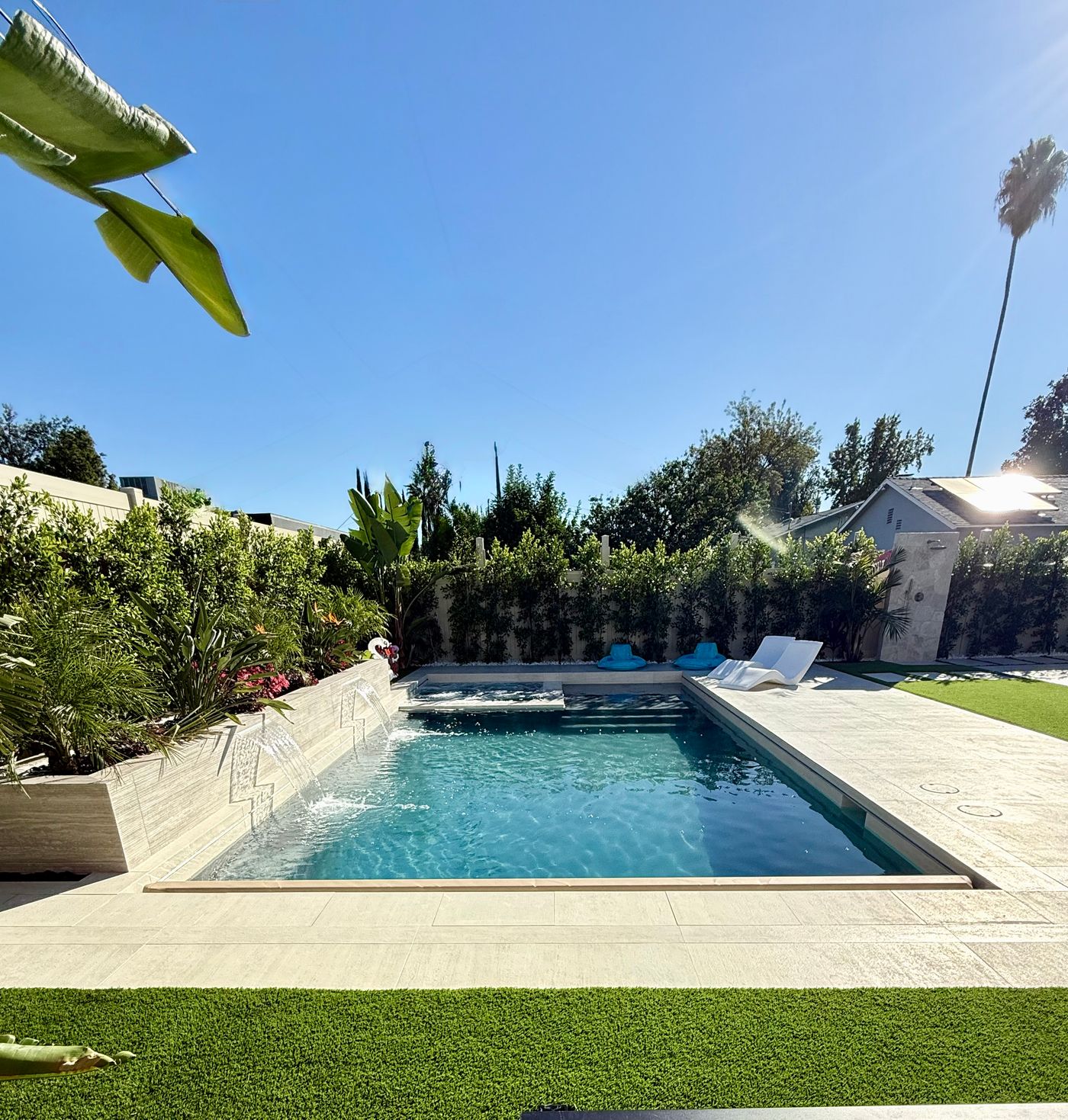 modern rectangular pool and spa with raised wall and water features in Woodland Hills.