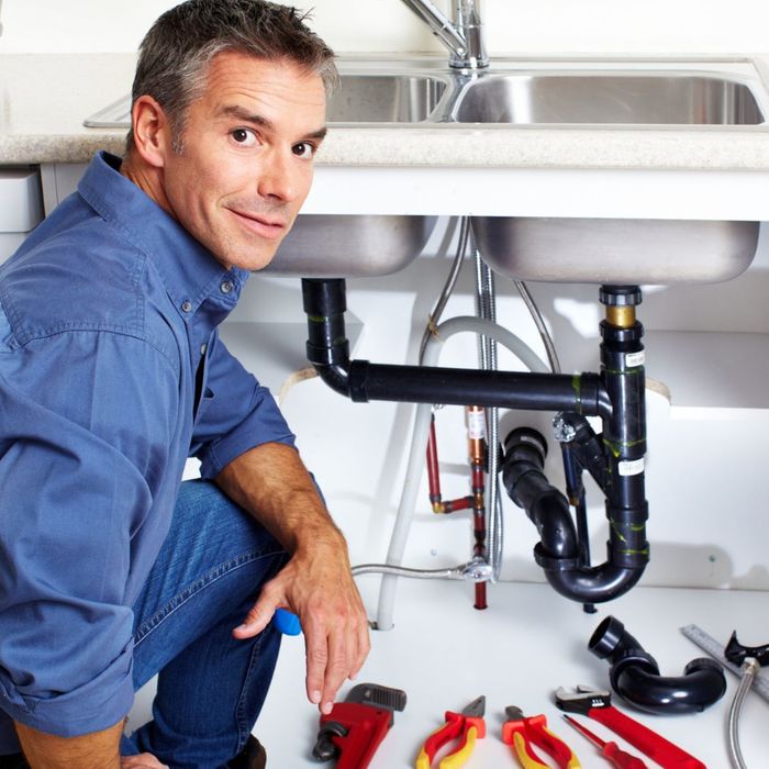 plumber working underneath a sink