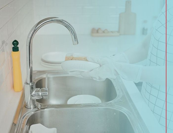 person doing dishes because she has hot water