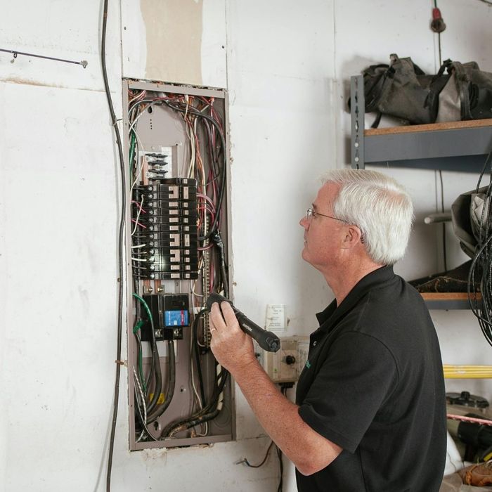 man checking electrical panel man checking electrical panel