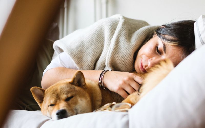 woman relaxes on clean couch with dog after upholstery cleaning removed pet odors 
