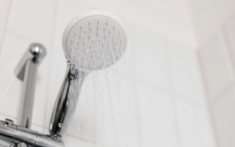clean shower running water with white tile 