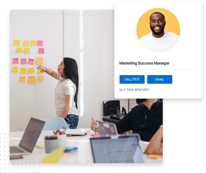 Young woman putting up notes in an office while a man looks on overlaid with details about Marketing Success Manager Marketing success manager