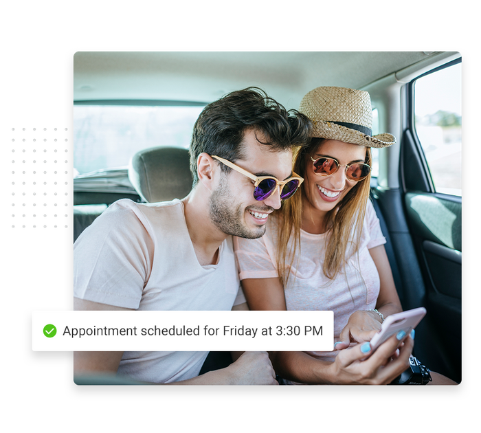 Smiling couple sitting in car overlaid with a checkmark that says 'Appointment scheduled for Friday at 3:30 PM' Franchise scheduling software