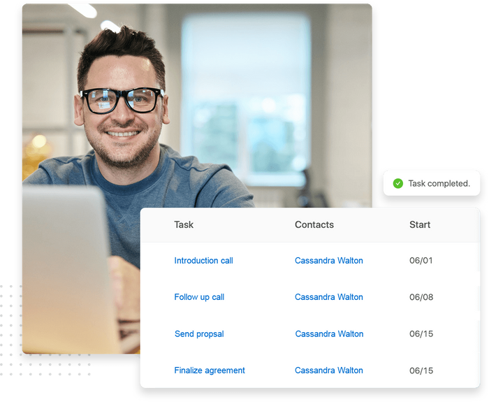 Smiling man with glasses working at a laptop overlaid with tasks management dashboard in the small business CRM Small business CRM contacts
