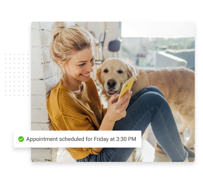 Smiling woman with phone and dog overlaid with a check mark that says 'Appointment scheduled for Friday at 3:30 PM' veterinarian scheduling software