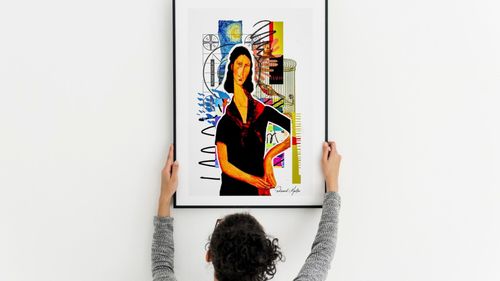 woman hanging art frame