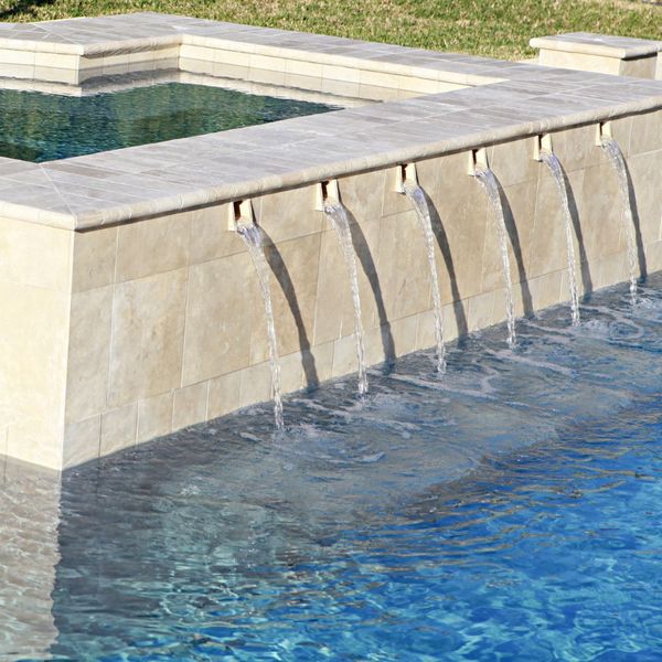 Multiple streams of water exiting a spa into a pool