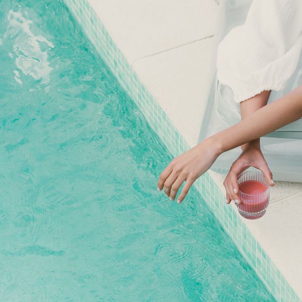 Woman relaxing by pool with a smoothie