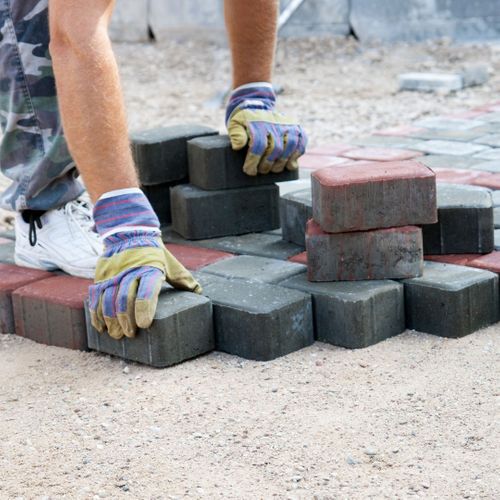 paver laying bricks down