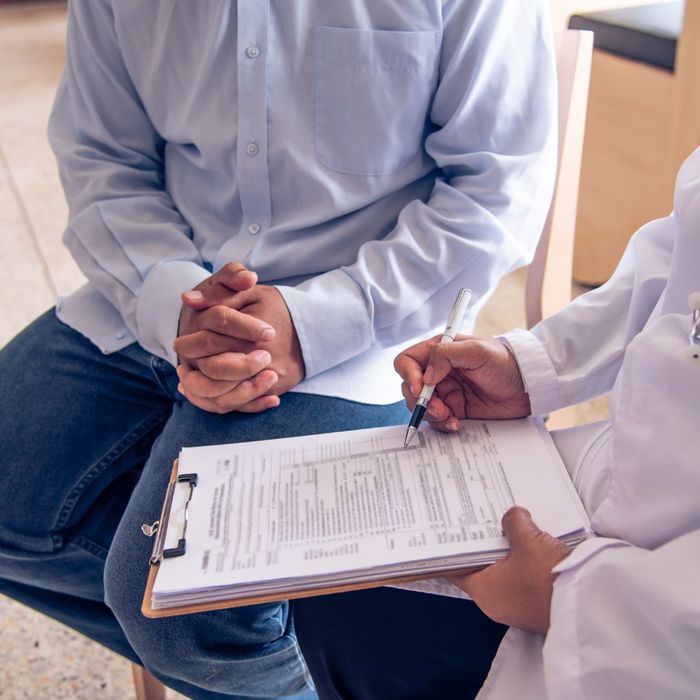 Doctor and patient sitting in chairs and filling out paperwork