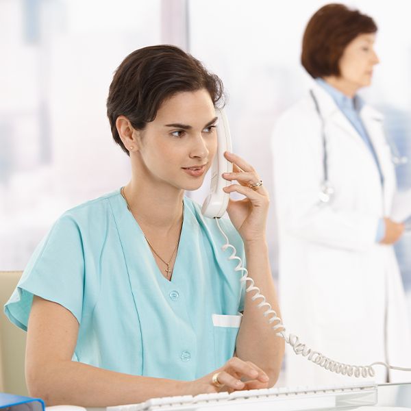 a nurse on the phone typing on a keyboard