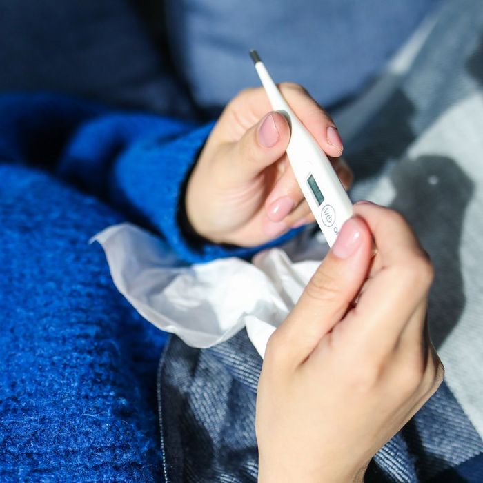 person checking a thermometer for a fever