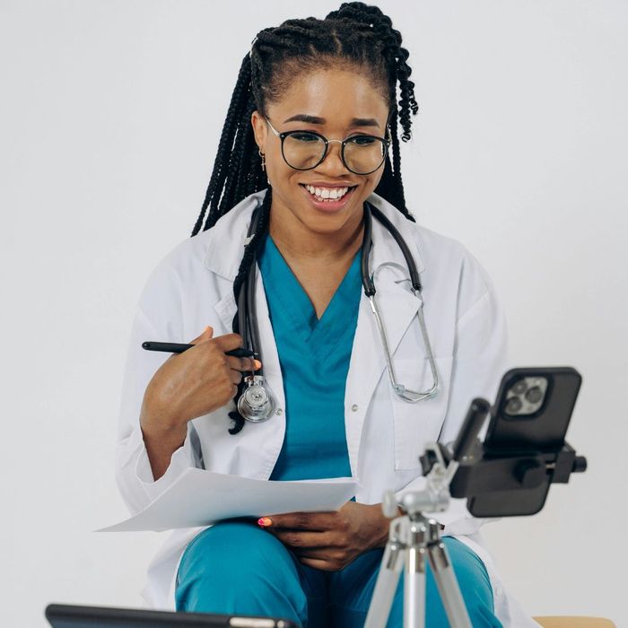 a doctor smiling at a video camera The Benefits of a Virtual Doctor Visit (3).jpg