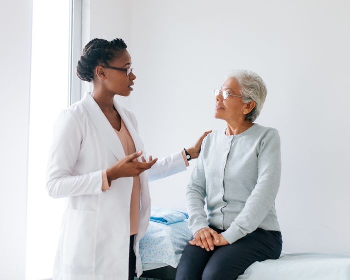 A doctor with her hand on a patient's shoulder