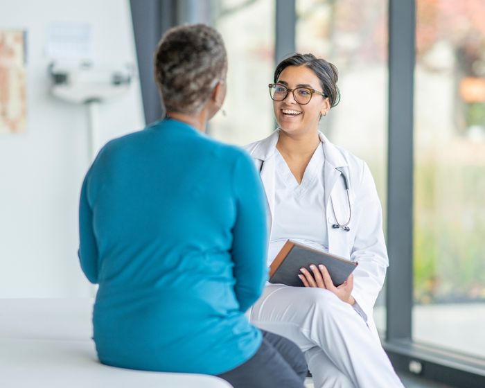 A doctor smiling while talking to a patient