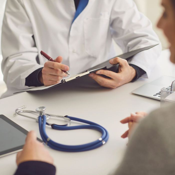 Doctor taking notes at table with patient
