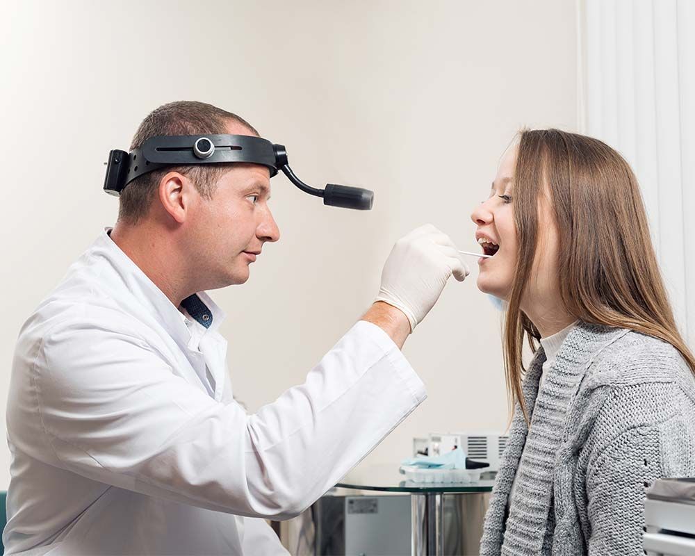 a doctor looking at a patients throat