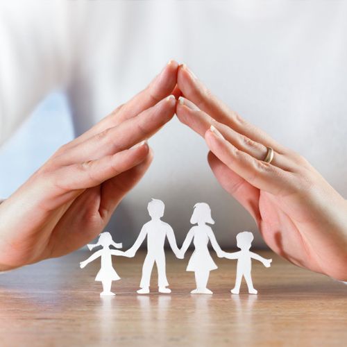 Person forming a roof with their hands over a paper cutout family