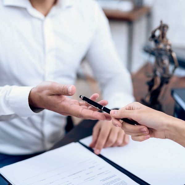 lawyer handing pen to client