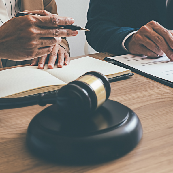 Two people looking over contracts at a legal desk