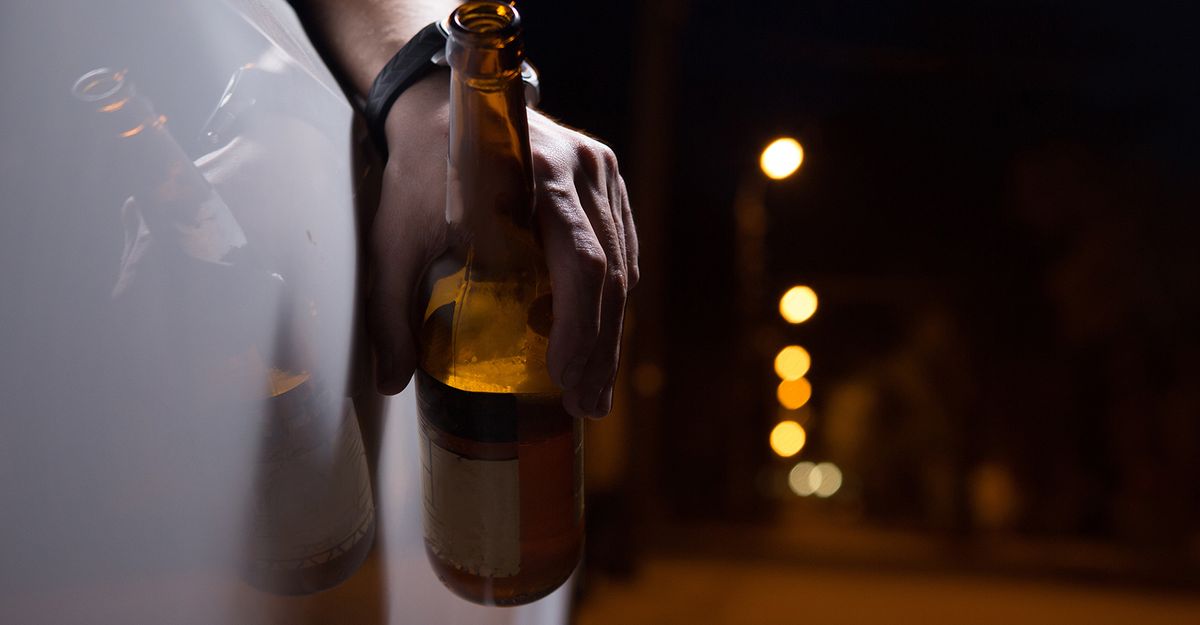 image of a person holding a beer bottle out of a car window