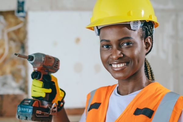 electrician wearing safety gear and holding drill