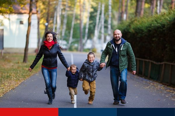 image of family of four holding hands walking down street