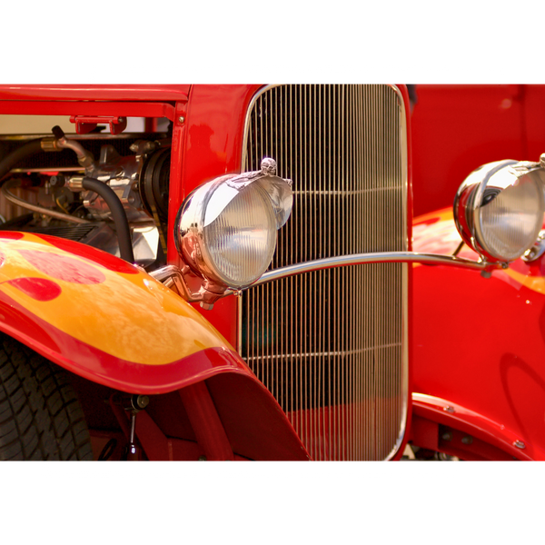 Front of a red hot rod with orange flames above the tires.