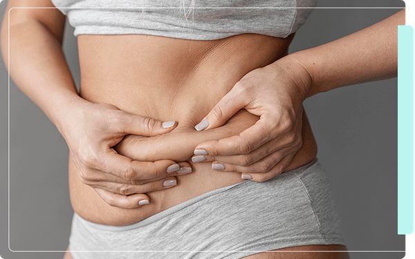 image of a woman pinching stomach fat