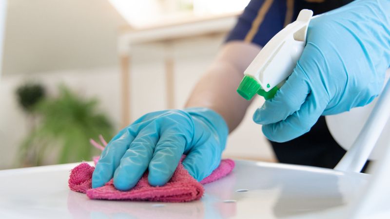 Cleaning surfaces with pink rag and cleaning spray