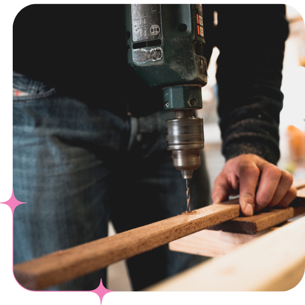 Handyman drilling a whole in wooden plank