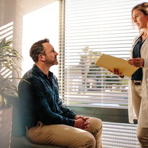 male patient sitting, talking to doctor
