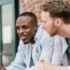two young men talking outdoors