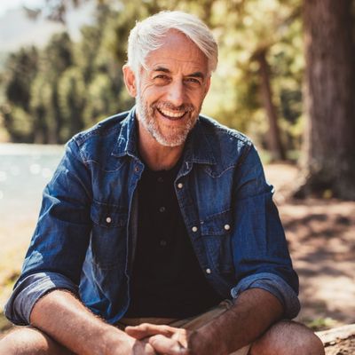 healthy graying man smiling at camera outdoors