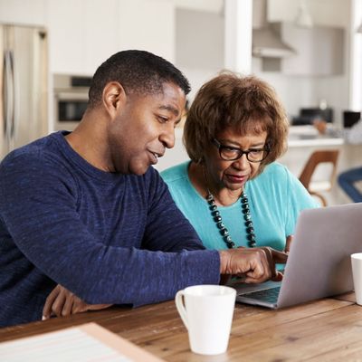 couple looking at laptop, man pointing at screen