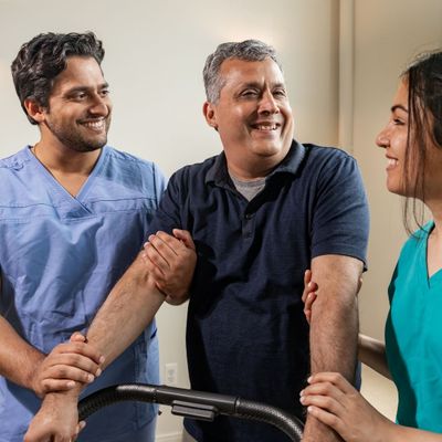 middle-aged man supported by nurses