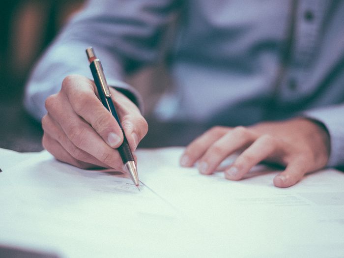 image of man signing papers image of man signing papers