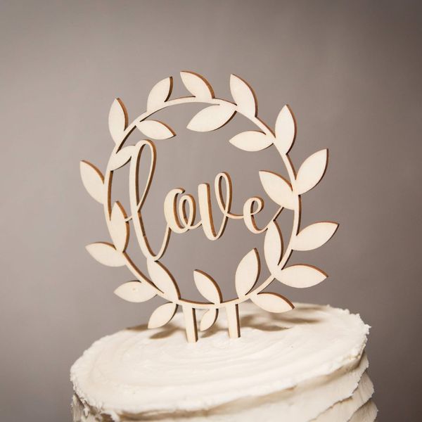 laser cut wood sign that says love on a wedding cake