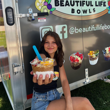 girl sitting in front of Beautiful Life Bowls food truck