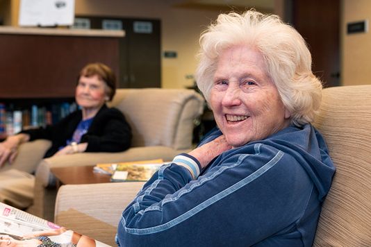 residents sitting on couch laughing