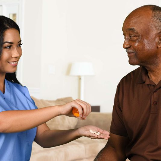 Nurse handing a senior medication